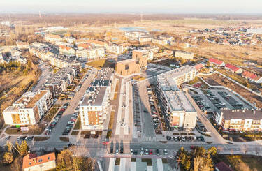 Osi istniejących budynk&oacute;w (kościoła i szkoły) przypominają kształtem...
