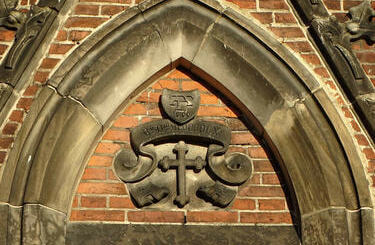Monogramy Alexisa Langera nad wejściem do kościoła